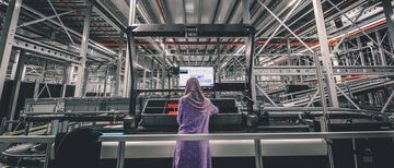 Eine Mitarbeiterin sieht auf den Bildschirm an ihrem Arbeitsplatz im Lager